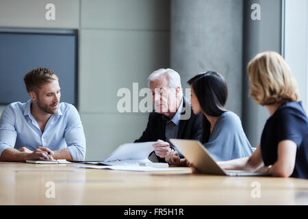 Business people discussing paperwork in conference room Stock Photo