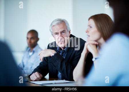 Senior businessman listening in meeting Stock Photo