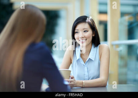 Smiling businesswomen talking on coffee break Stock Photo