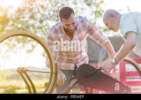 Father and adult son fixing bicycle Stock Photo