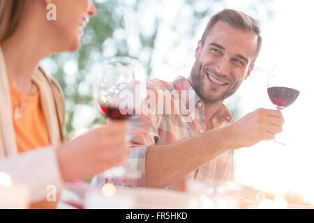 Smiling young couple drinking red wine outdoors Stock Photo