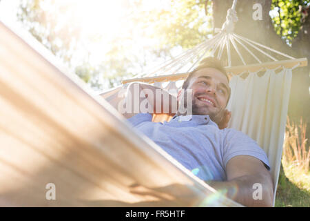 Smiling young man relaxing in summer hammock Stock Photo