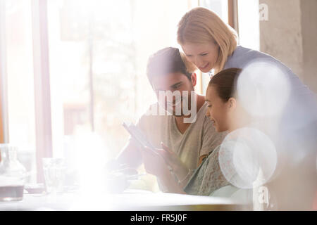 Family using digital tablet in sunny cafe Stock Photo