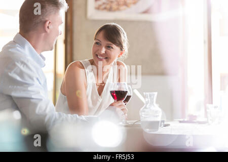 Couple drinking wine and talking at cafe Stock Photo