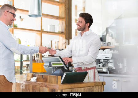 Customer paying worker at cafe cash register Stock Photo