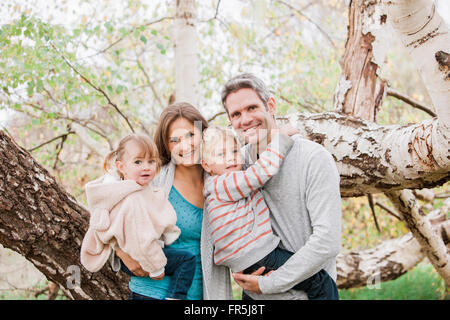 Portrait smiling family in front of tree Stock Photo