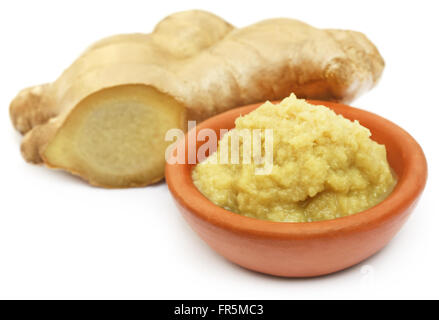 Fresh mashed ginger in a bowl and whole over white background Stock Photo