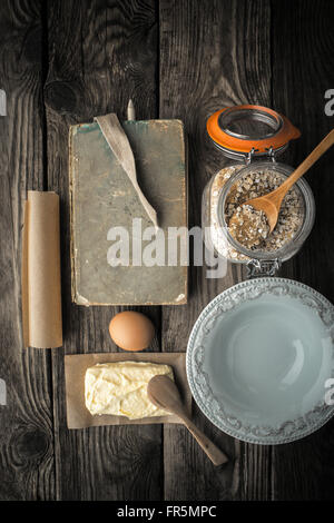 Recipe book, plate and ingredients for cookies on a wooden table vertical super still life Stock Photo