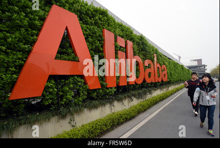 Hangzhou, March 21. 21st Mar, 2016. People walk past a logo of China's e-commerce giant Alibaba in Hangzhou, capital of east China's Zhejiang Province, March 21, 2016. Alibaba China retail marketplaces real-time gross merchandize value (GMV) in fiscal year 2016 reached three trillion RMB (about 463 billion U.S. dollars) at 2:58 p.m. (0658 GMT) on March 21, 2016. This means Alibaba Group, China's leading e-commerce company, might exceed Wal-Mart and become the world's biggest retail platform in fiscal year 2016, according to analysis. © Wang Dingchang/Xinhua/Alamy Live News Stock Photo