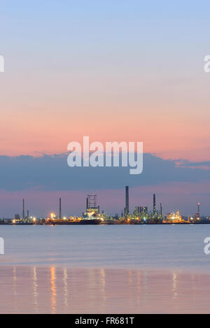 Petrochemical  refinery at sea at sunset Stock Photo