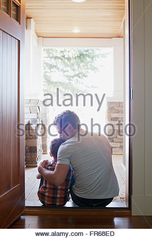 father and son sitting in doorway