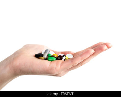 Closeup of female hand holding all sorts of pills and tablets on white background Stock Photo