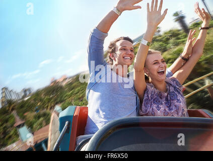 Exhilarated young couple riding amusement park ride Stock Photo