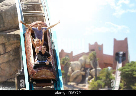 Enthusiastic friends cheering and riding log amusement park ride Stock Photo