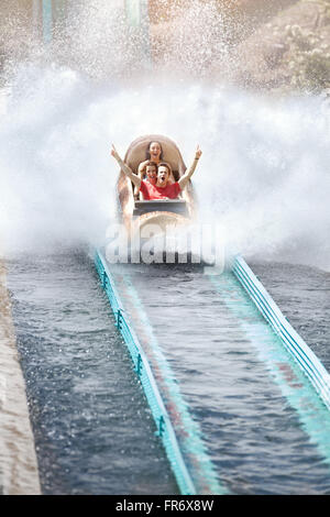Enthusiastic friends cheering and riding water log amusement park ride Stock Photo