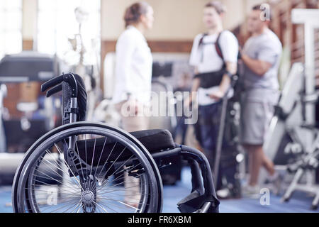 Man receiving physical therapy with wheelchair in foreground Stock Photo