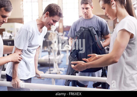 Physical therapists guiding man walking Stock Photo