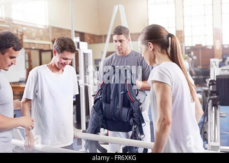 Physical therapists helping man walk Stock Photo