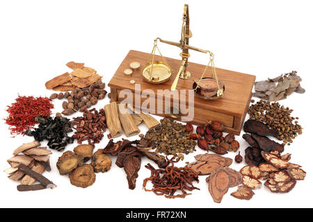 Chinese herb ingredients used in traditional herbal medicine with old brass scales over white background. Stock Photo