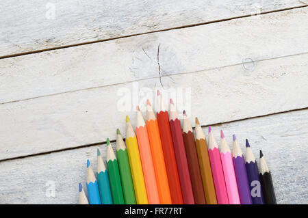 Some colored pencils on a white wooden table. Empty copy space for editor's text. Stock Photo