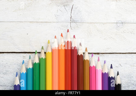 Some colored pencils on a white wooden table. Empty copy space for editor's text. Stock Photo