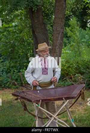 Grandpa in Ukrainian costume playing the dulcimer Stock Photo