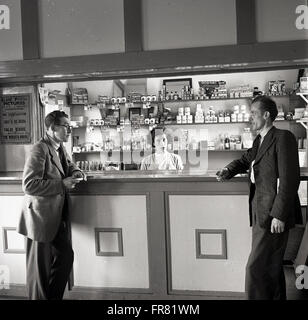 1950s historical. two local men chat in the bar of the community centre, Clune, Ireland. Stock Photo