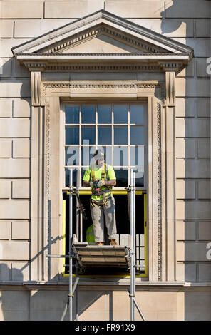 London, England, UK. Workman on scaffolding by a government building in Whitehall Stock Photo
