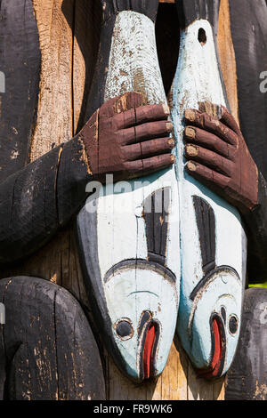 Detail of a figure holding salmon carved into a totem pole, Totem Bight State Historical Park, Ketchikan, Southeast Alaska, USA, Spring Stock Photo
