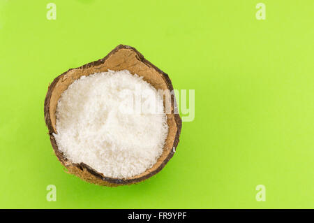 Coconut powder in coconut shell on green background Stock Photo