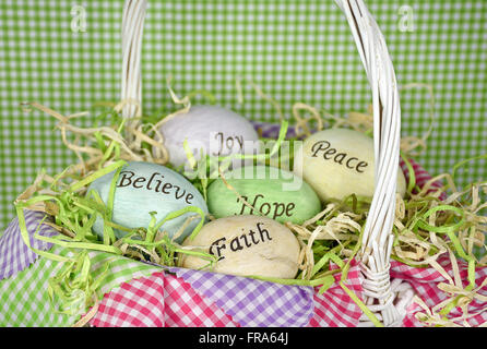 Inspirational words on Easter eggs in white wicker basket with gingham fabric. Stock Photo