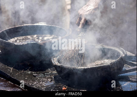 Painting pots with tannin extracted from the red mangrove - clay pots Production Stock Photo