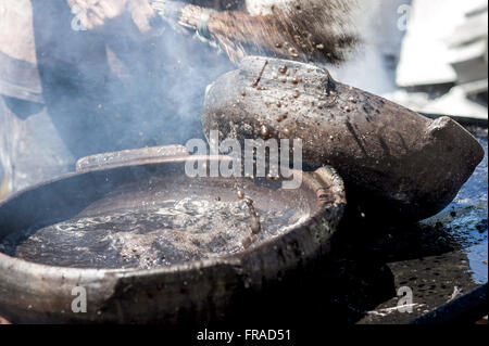 Painting pots with tannin extracted from the red mangrove - clay pots Production Stock Photo