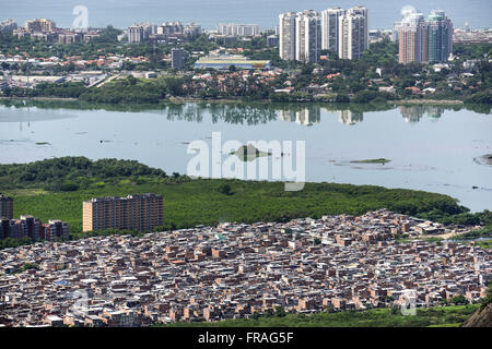 Aerial view of the Rio das Pedras favela with Lagoa da Tijuca and townhouses at Barra da Tijuca neighborhood Stock Photo