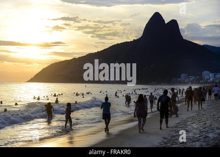 Bathers on Ipanema beach at sunset Stock Photo