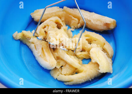 Mashing Soft Overripe Bananas in a Blue Bowl Stock Photo