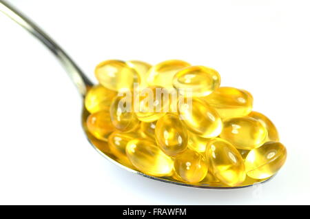 fish oil capsules on spoon isolated on white background Stock Photo