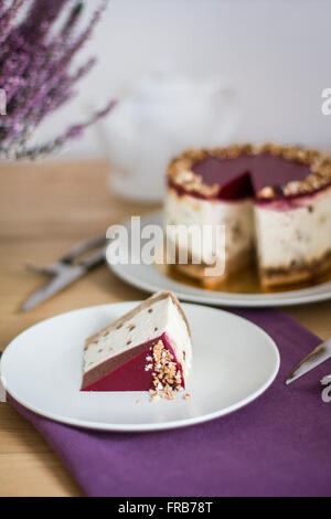 Piece of fruit cheesecake on the plate with whole cake in background Stock Photo