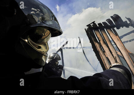 Firefighters putting out fire in wooden house burned Stock Photo