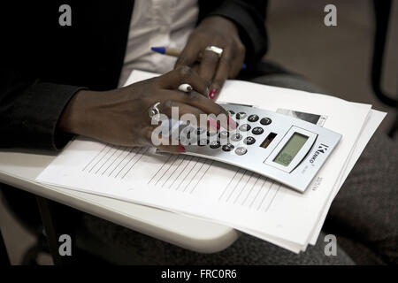 Detail of female hand using calculator Stock Photo