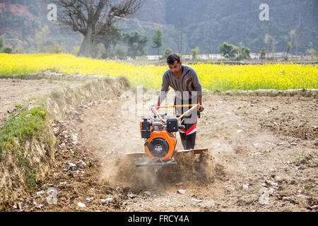 Farmer using a mini tiller in Nuwakot, Nepal Stock Photo