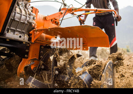 Farmer using a mini tiller in Nuwakot, Nepal Stock Photo