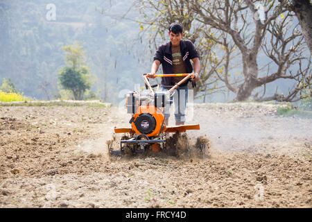 Farmer using a mini tiller in Nuwakot, Nepal Stock Photo