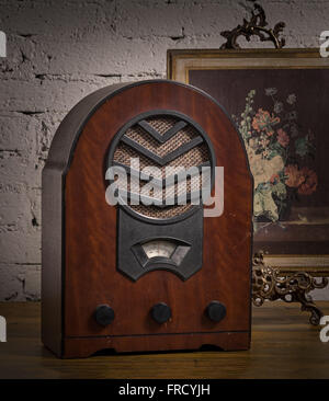 Old wooden radio and golden framed painting on wooden table Stock Photo