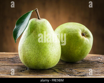 Two pears with leaf on wooden background. Stock Photo