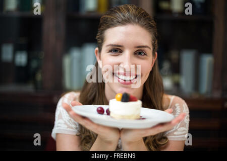 Happy woman at restaurant holding desert in plate Stock Photo