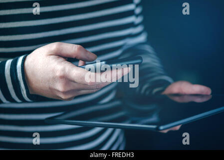 Smartphone and tablet data synchronization, woman syncing files and documents on personal wireless electronic devices at home, s Stock Photo