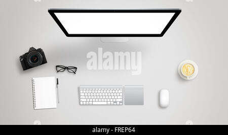 Isolated computer display for mockup on work desk with keyboard, mouse, coffee, camera, notebook, glasses, pencil. Stock Photo