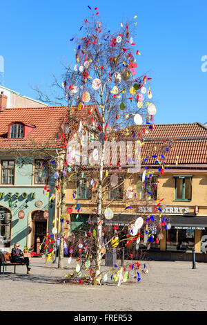 Kalmar, Sweden - March 17, 2016: A birch tree has been decorated with feathers and paper eggs and placed on a town square to cel Stock Photo