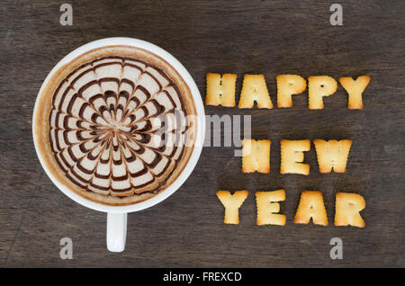 A cup of latte art and alphabet 'happy new year' made from bread cookies Stock Photo